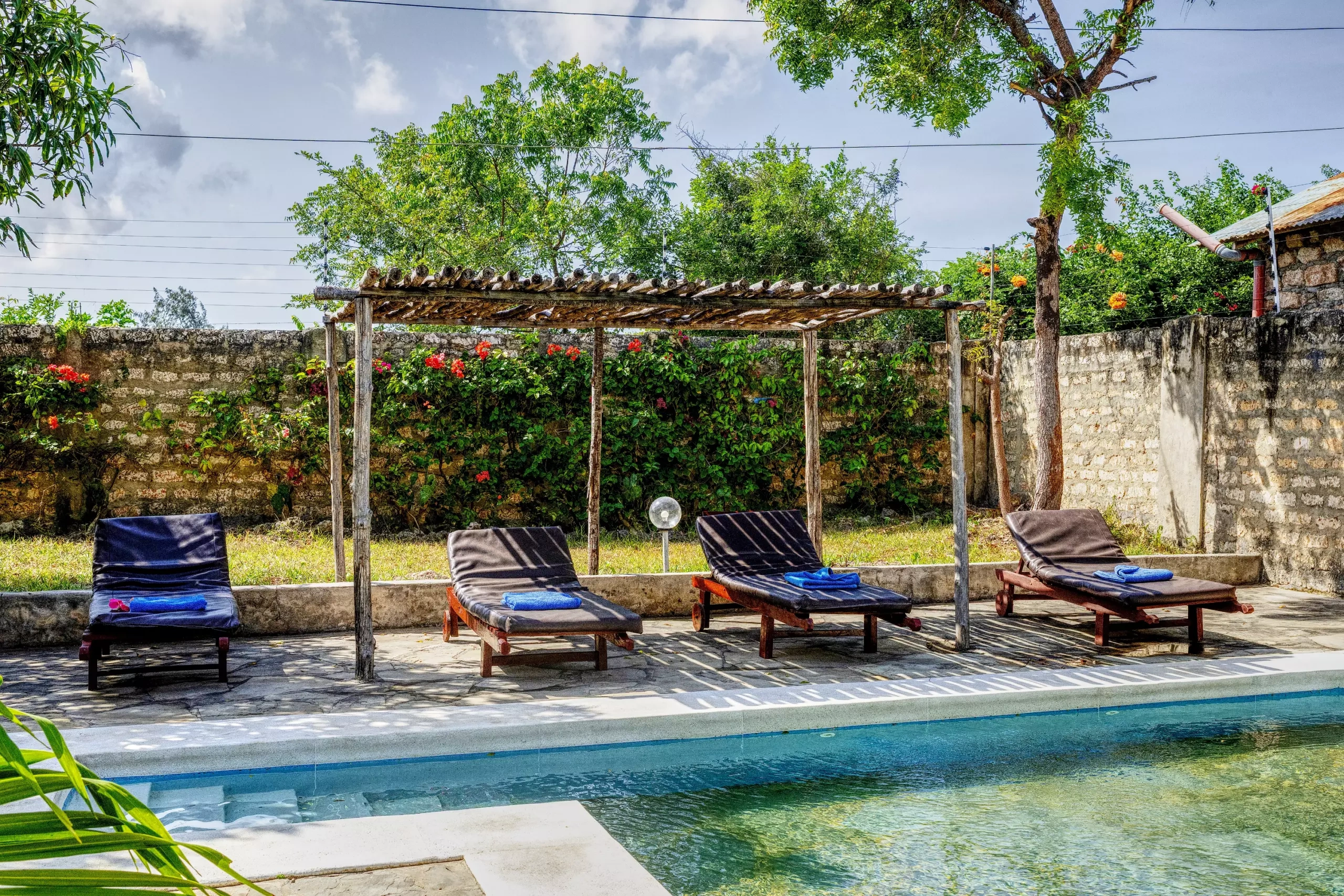 Pool with sun loungers and beds at Dacha Diani Apartments